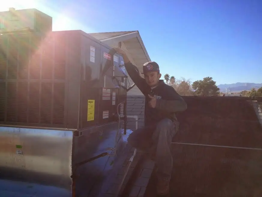 HVAC technician performing AC Tune-Up on a rooftop unit in Sugar Grove